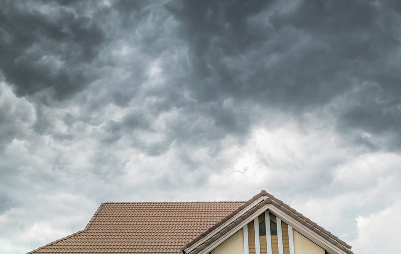 Dark cloud ready to rain heavily on a house